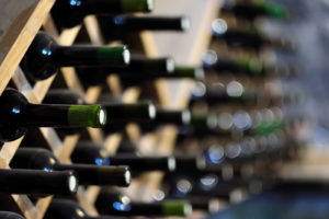 Wine bottles stored horizontal on wine racks in a storage unit