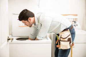 A man moving a washer and dryer