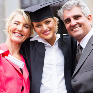 A college graduate smiles with her parents on graduation day before she moves back home after college