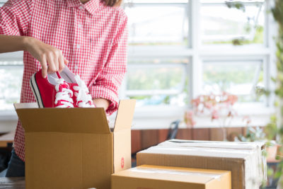 A woman placing items into a box before packing a storage unit