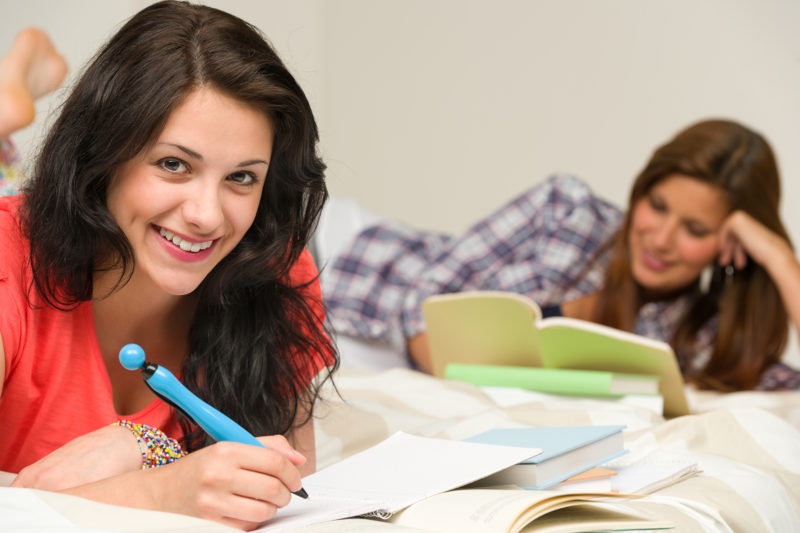 Two college roommates happily studying together