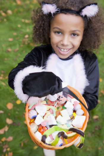 A young girl enjoys trick-or-treating before storing her costume
